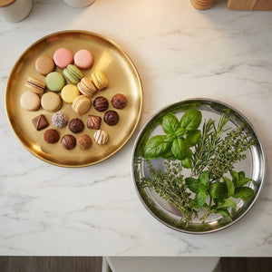 Plateau miroir rond disposé en centre de table avec décorations dorées