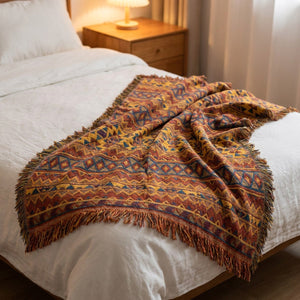 Jeté de canapé bohème drapé au pied d'un lit dans une chambre chaleureuse