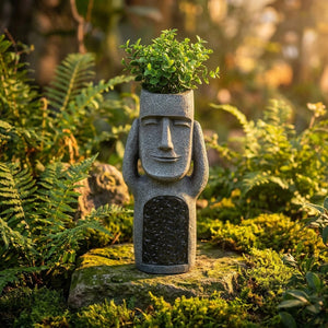 Statue Moai ornement de jardin avec plante verte dans la tête creuse parmi les fougères