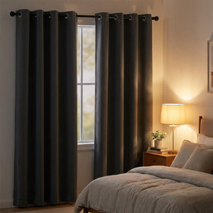 Rideau occultant gris foncé suspendu dans une chambre cosy en soirée