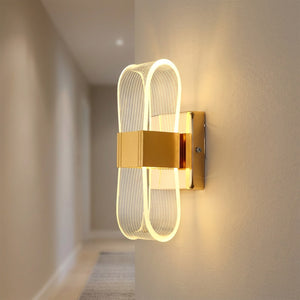 Applique murale dorée dans un couloir épuré diffusant une lumière chaude sur le mur