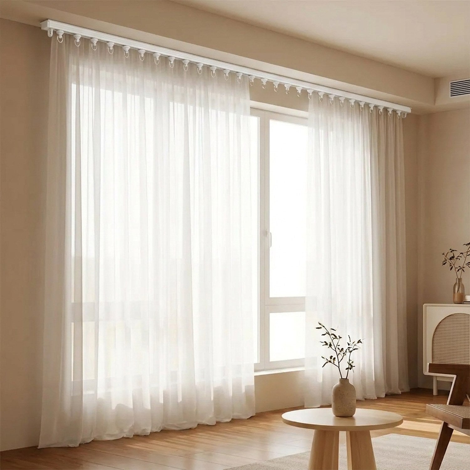 Rail de rideau discret au plafond avec un long voilage blanc dans un salon lumineux
