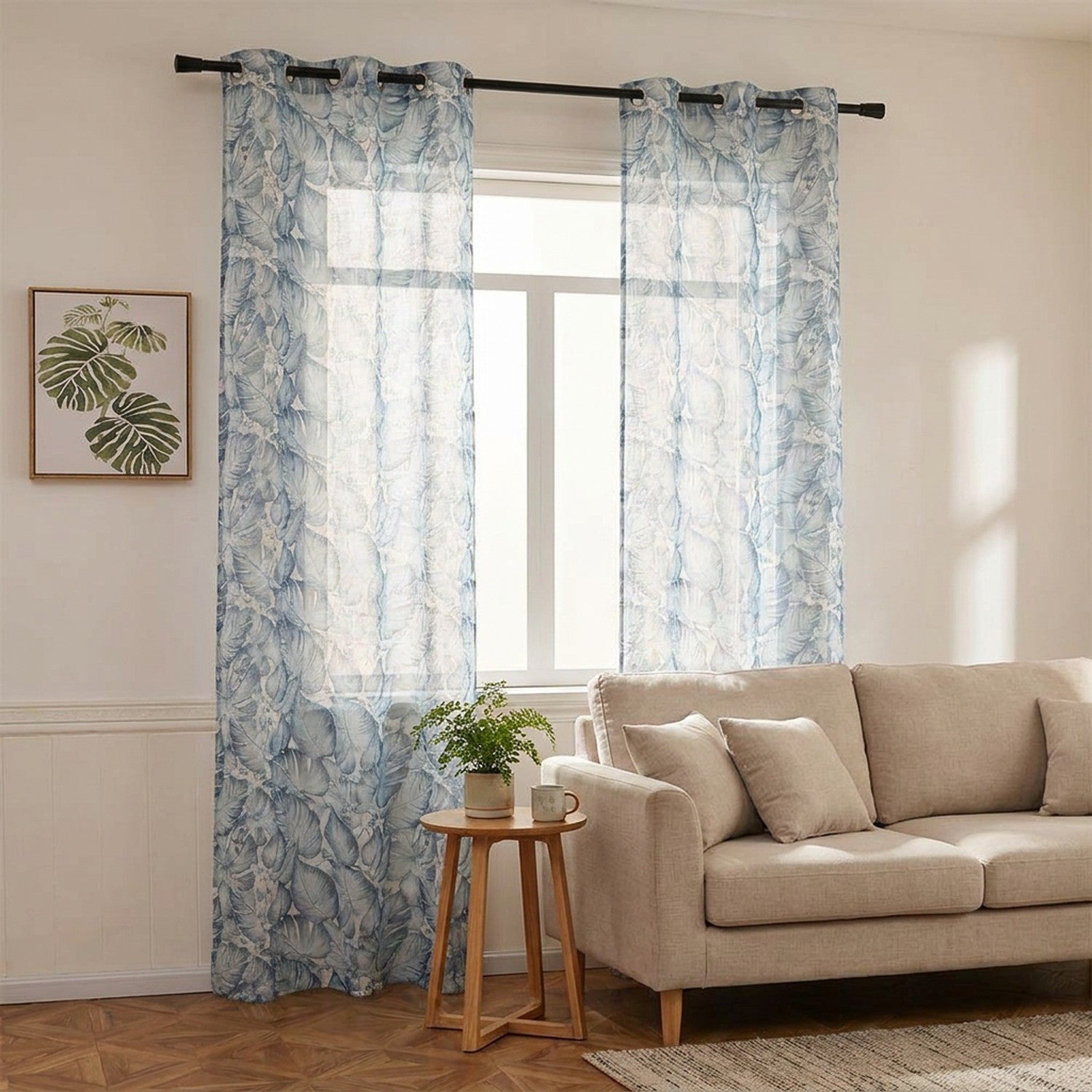 Salon lumineux avec rideau voilage bleu à feuillage tropical encadrant une fenêtre