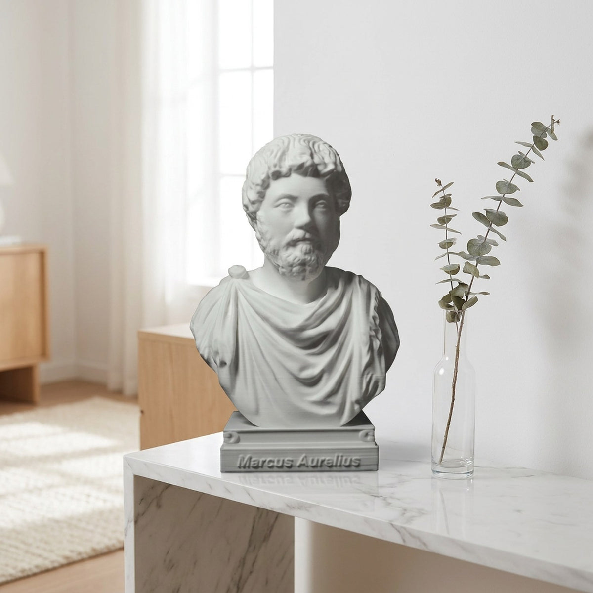 Buste de Marc Aurèle sur une console en marbre blanc avec une branche d'eucalyptus dans un salon clair