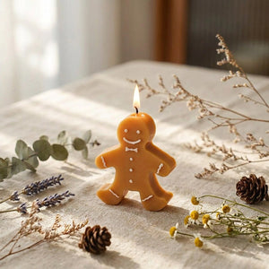 Bougie pain d'épice de Noël allumée sur nappe en lin avec fleurs séchées et eucalyptus