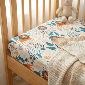 Coin du drap housse bébé avec élastique ajusté et doudou sur un lit de berceau