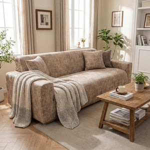 Housse de canapé beige installée dans un salon lumineux