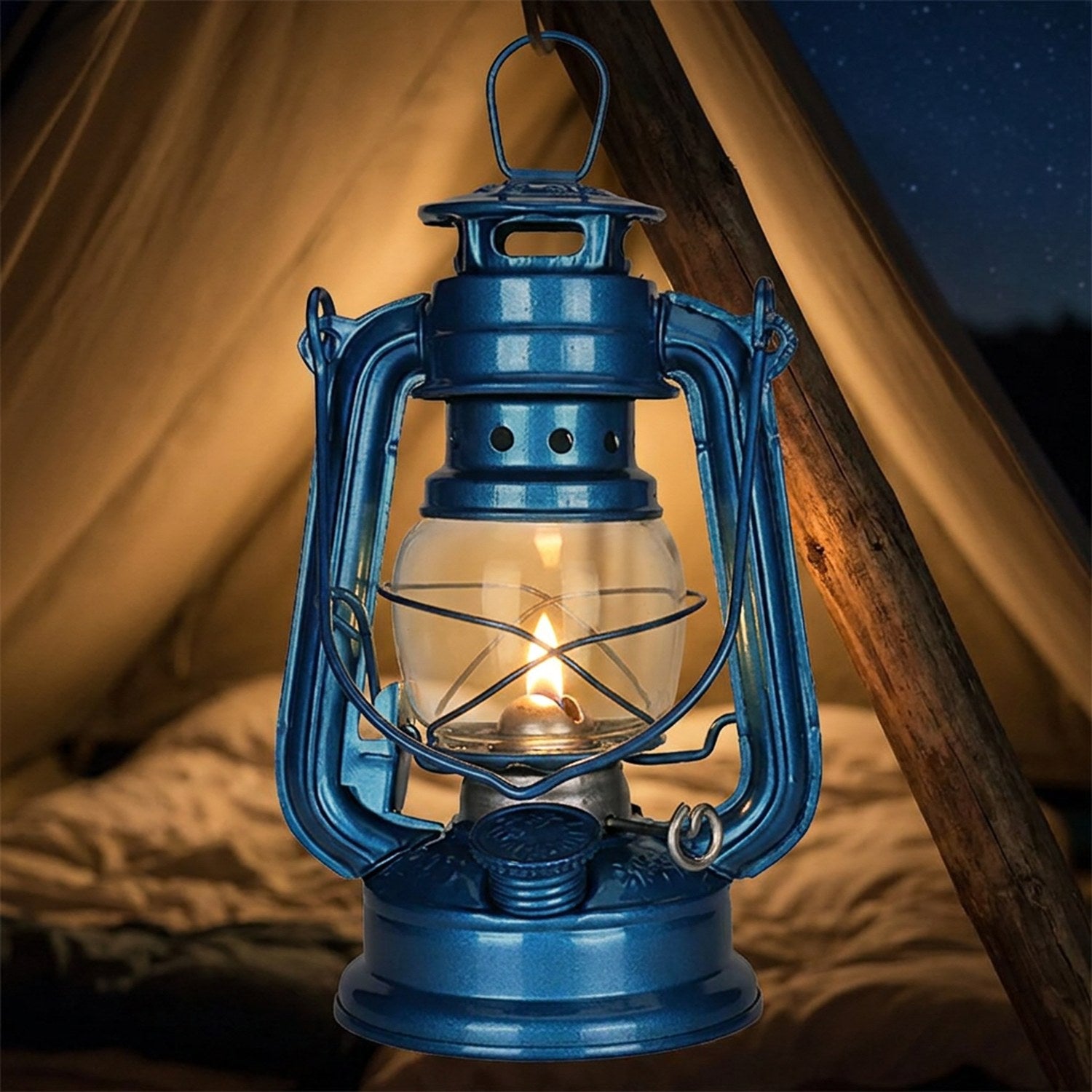 Lampe à pétrole bleue suspendue à un mât de tente allumée la nuit