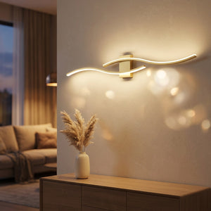 Applique murale dorée double courbe LED éclairant un salon moderne au dessus d'un buffet en bois