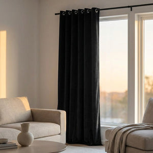 Rideau en velours noir dans un salon lumineux au coucher du soleil avec canapé beige