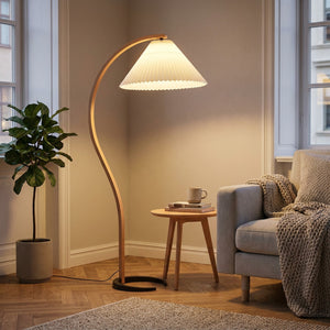 Lampadaire arc bois nordique blanc dans un salon scandinave avec fauteuil
