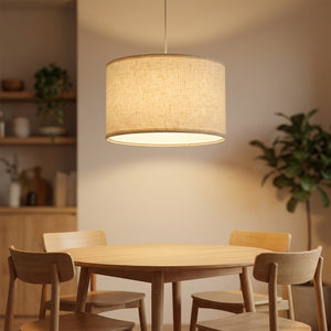 Abat-jour cylindrique en lin suspendu au-dessus d'une table à manger en bois
