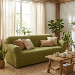 Housse de canapé motif feuilles verte dans un salon lumineux