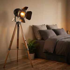 Lampadaire projecteur vintage près d'un lit dans une chambre cosy