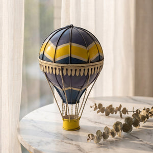 Ballon à air chaud en métal forgé sur surface en béton près d'une fenêtre lumineuse dans un intérieur minimaliste