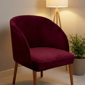 Housse de chaise velours bourgogne dans un coin salon avec lampadaire et plante