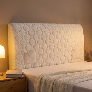 Housse de tête de lit matelassée dans une chambre tamisée avec lampe de chevet