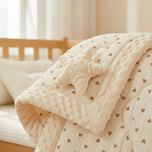 Gros plan du doudou étoile et de la bordure moelleuse de la couette bébé