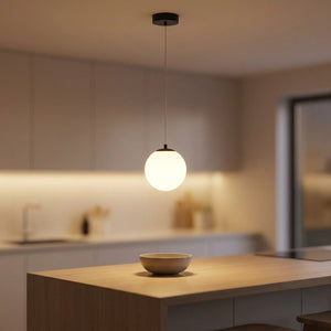 Suspension boule en verre opalin noire suspendue au-dessus d'un îlot de cuisine