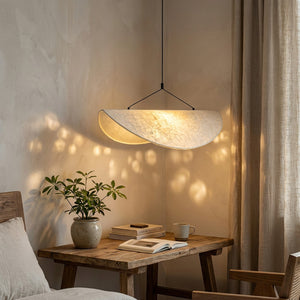 Suspension Wabi Sabi au-dessus d'un bureau en bois dans un coin lecture, lumière dorée tamisée