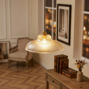 Suspension verre nervuré vintage dans un salon de style parisien avec parquet et bokeh doré