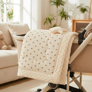 Couette bébé pliée posée sur une poussette dans un salon lumineux