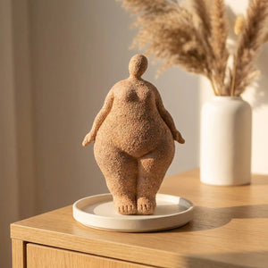 Statuette de femme debout en résine sur plateau blanc avec herbes de pampa en arrière-plan