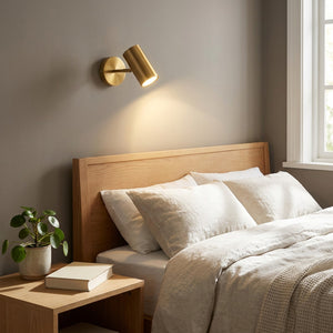 Applique murale LED dorée dans une chambre au-dessus de la tête de lit