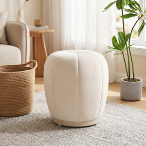 Pouf tabouret citrouille crème dans un salon scandinave près d'une plante verte