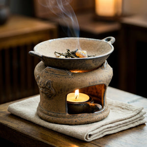 Brûle-parfum en céramique zen rétro avec une bougie allumée diffusant une lueur chaude sur une table en bois