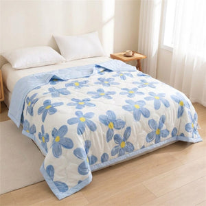 Couverture d'été à motif floral bleu sur un lit complet dans une chambre claire