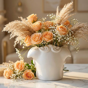 Vase décoratif style grec blanc avec roses pêche et pampa, vue de côté sur surface en marbre