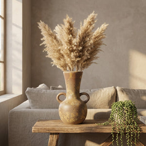 Vase grec amphore en céramique sur une console dans un salon bohème avec pampa