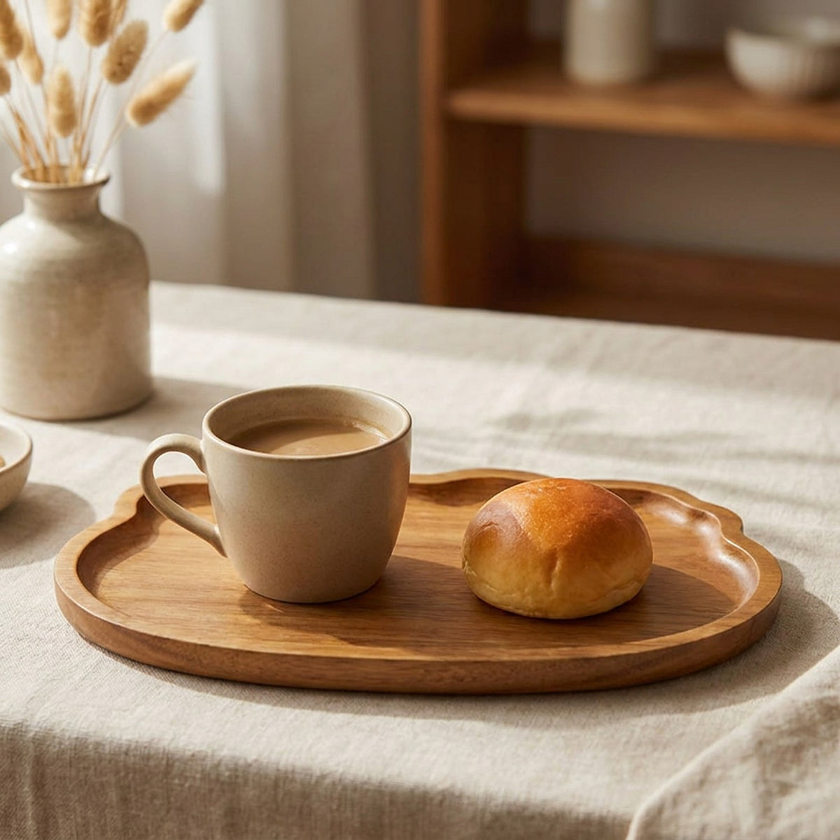 Plateau en bois garni d'un café et d'une brioche sur une table de petit déjeuner