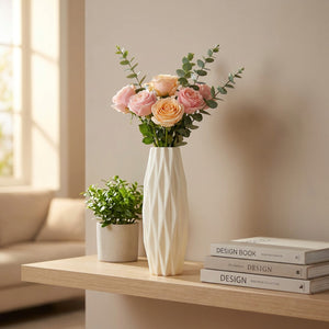 Vase origami blanc sur une étagère en bois avec des roses et une plante verte