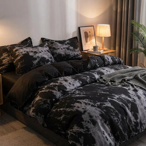 Parure de lit effet marbre noir sur un lit dans une chambre chaleureuse le soir