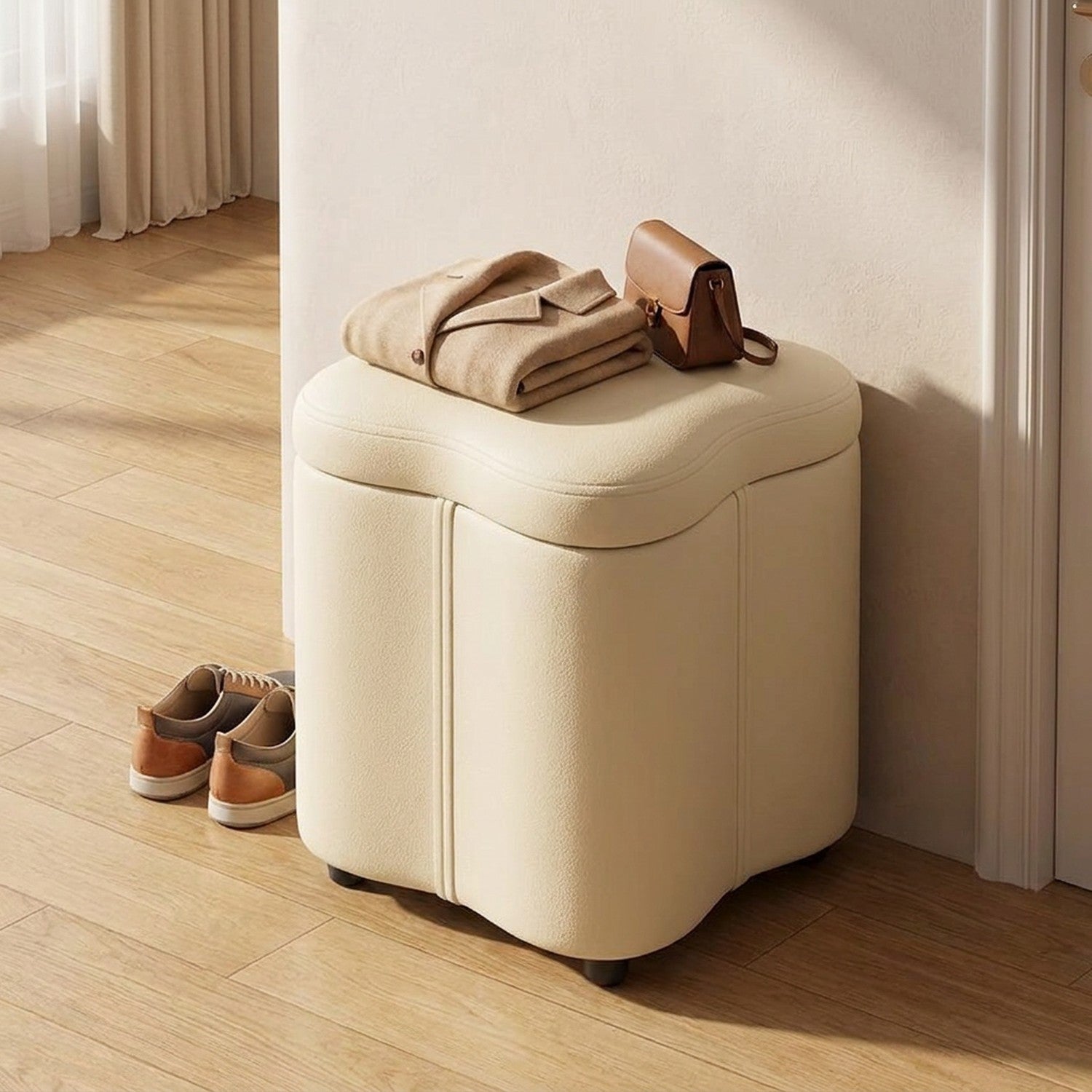 Tabouret coffre crème utilisé comme siège dans une entrée avec un manteau plié et un sac posés dessus