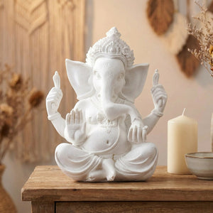 Statue Ganesh blanche sur une console d'entrée près d'une bougie