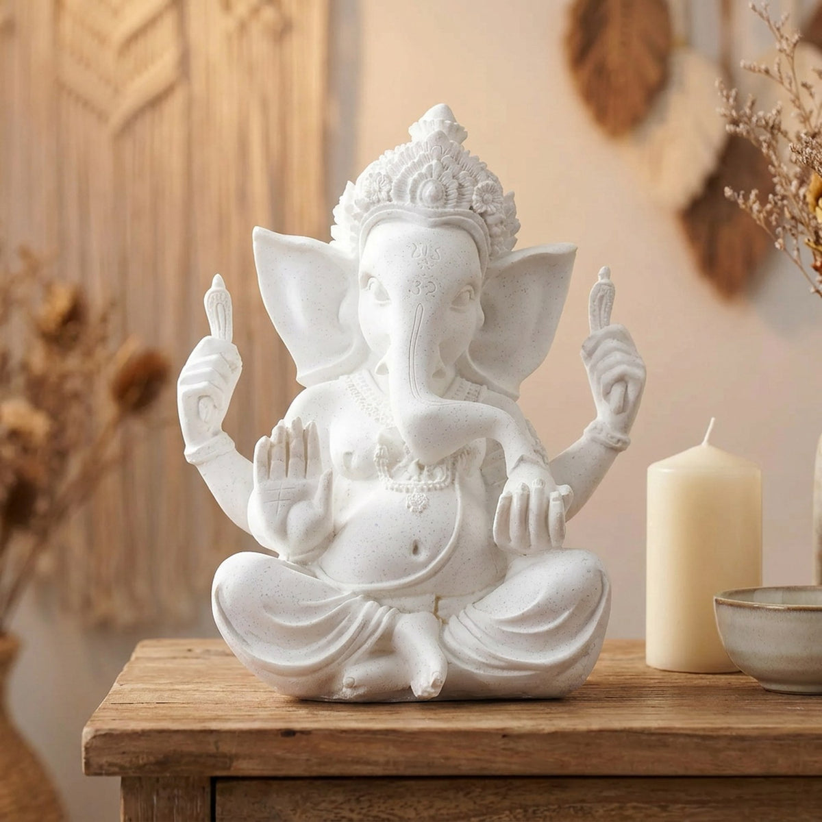 Statue Ganesh blanche sur une console d'entrée près d'une bougie