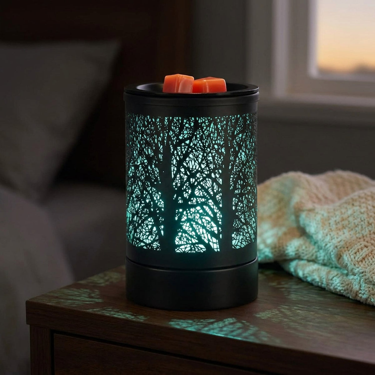 Brûle-parfum électrique noir sur une table de chevet avec lumière turquoise le soir
