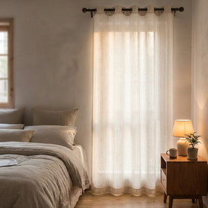 Voilage rayé écru translucide à la fenêtre d'une chambre douce et lumineuse