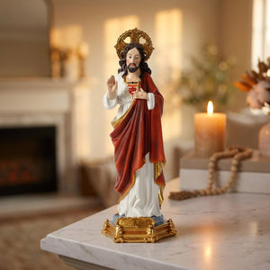 Statue du Sacré-Cœur de Jésus sur une cheminée en marbre avec une bougie allumée