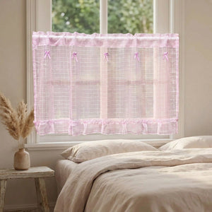 Rideau court en tulle rose installé à la fenêtre d'une chambre romantique