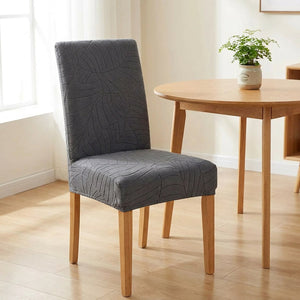 Housse de chaise grise à motif jacquard feuillage près d'une table ronde scandinave