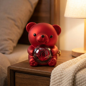 Boîte à bijoux ourson rouge sur une table de chevet avec un plaid
