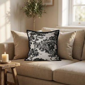 Housse de coussin toile de Jouy sur un canapé beige entourée de coussins neutres
