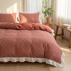 Parure de lit vichy rouge sur un lit dans une chambre campagne lumineuse avec plante