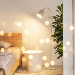 Lampadaire blanc col de cygne allumé dans une chambre moderne