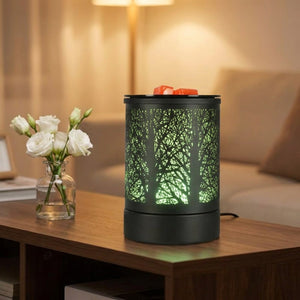 Brûle-parfum électrique noir sur une console de salon avec lumière verte et fleurs blanches
