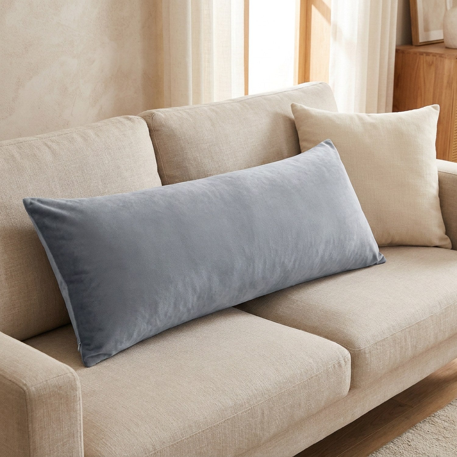 Housse traversin en peluche grise posée sur un canapé en lin beige